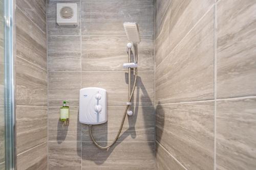 a shower in a bathroom with a soap dispenser at The Blossoms Studio Apartments in Liverpool