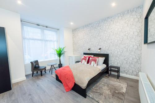 a bedroom with a bed with red pillows at The Blossoms Studio Apartments in Liverpool