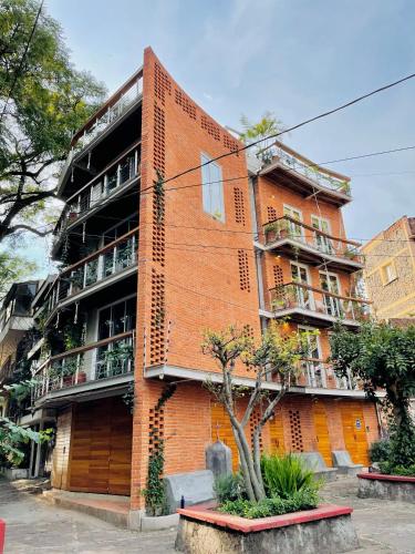 a red brick building with a tree in front of it at Sisao Hotel-Café in Cuernavaca