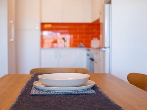 a bowl on a plate on a table in a kitchen at Astrids at Central Park - 2BR l Lake & Mountain Views l Central Location l WiFi in Jindabyne