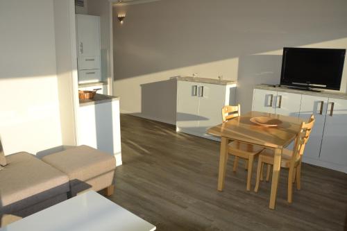 - une cuisine et une salle à manger avec une table et un canapé dans l'établissement Meerblick FeWo Nr A-107, à Sierksdorf