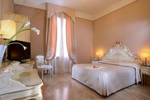 a bedroom with a white bed and a large window at Hotel Canaletto in Venice