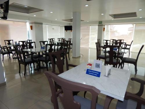 una sala da pranzo con tavoli e sedie in un edificio di Best Western Minatitlan a Minatitlán