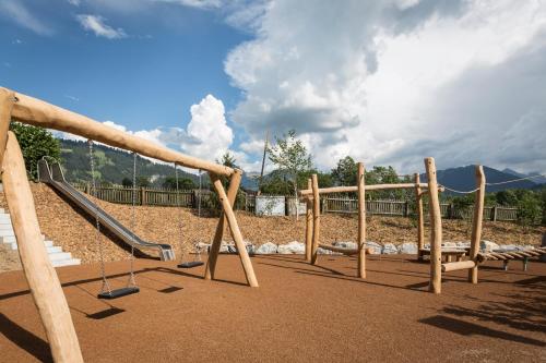 a playground with a slide in a park at Hotel Spitzhorn Superieur in Gstaad