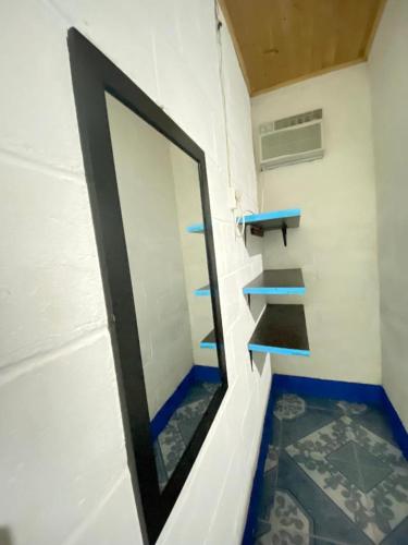a mirror in a room with blue shelves at HOSTAL EL DESCANSO in Capurganá