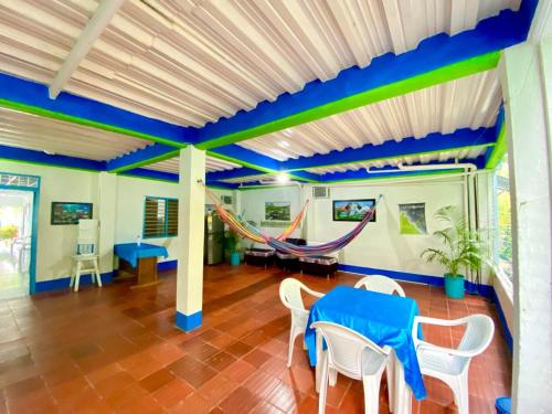 a room with a table and a hammock in it at HOSTAL EL DESCANSO in Capurganá