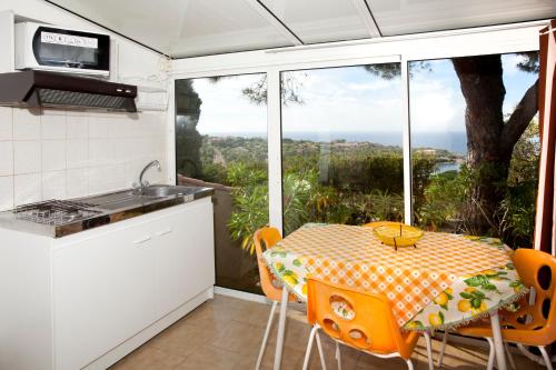una pequeña cocina con mesa y ventana en Residence San Damiano - Location Appartements, Studios & Chambres en Algajola