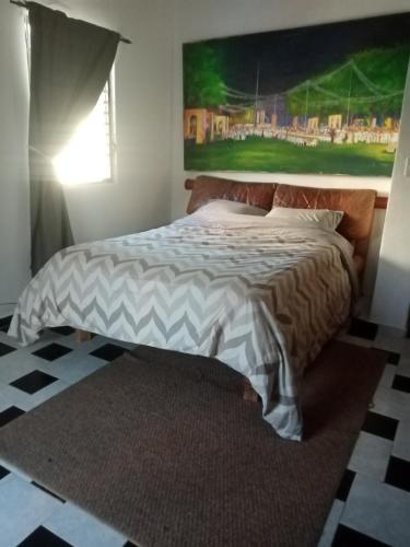 a bedroom with a bed with a painting on the wall at Caribbean Paradise in Cancún