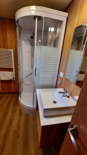 y baño con lavabo blanco y ducha. en Hermoso 2 ambientes, céntrico, 4 pax, muy cálido y cómodo 18V4 en San Martín de los Andes