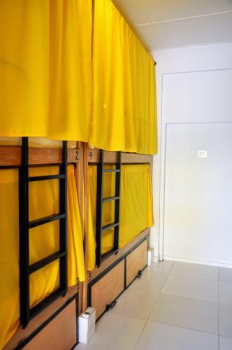 a room with yellow curtains in a room at Bona Vida Hostel in Ríohacha