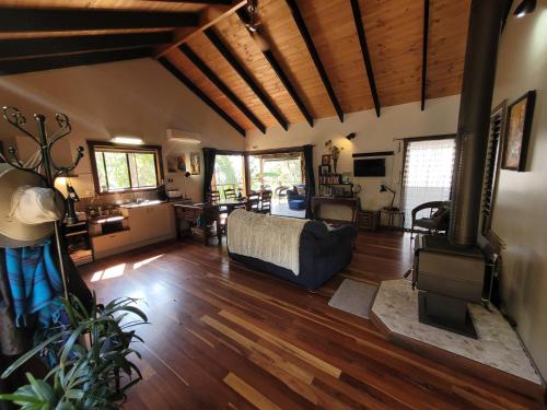 un soggiorno con divano e pavimenti in legno di Kookaburra Cottage at Uralba Eco Cottages a Upper Horseshoe Creek