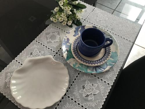 a table with a cup and a plate on it at Charmoso apto com clima de casa em Canasvieiras in Florianópolis