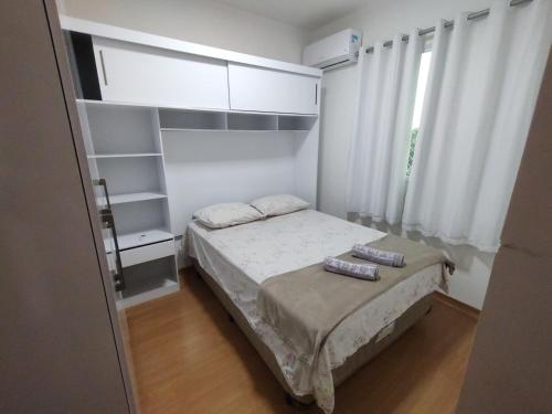 um pequeno quarto com uma cama e armários brancos em APTO, 2/4, 2 ar-condicionados e bem localizado. em Palmas