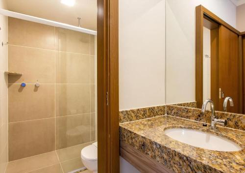 a bathroom with a sink and a shower and a toilet at Ondas Praia Resort in Porto Seguro