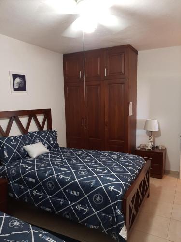 um quarto com uma cama e um armário de madeira em Villa Costal 111 em San Felipe de Puerto Plata