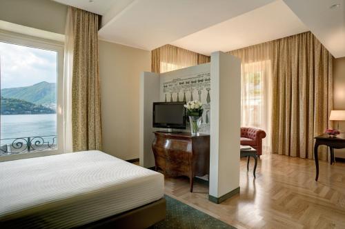 a hotel room with a bed and a large window at Palace Hotel Lake Como in Como