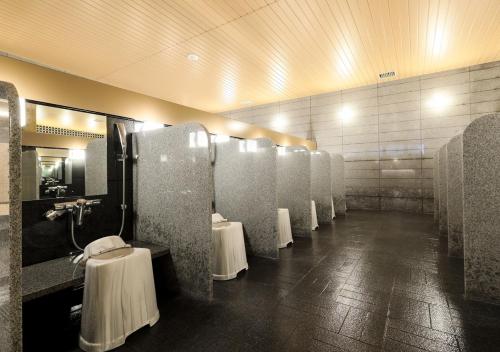 a bathroom with a row of urinals in a room at APA Hotel & Resort Niigata Ekimae Odori in Niigata