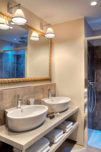 a bathroom with two sinks and a mirror at Palace Hotel Lake Como in Como