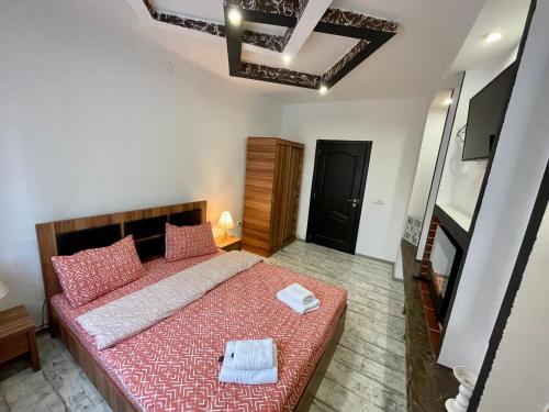 een slaapkamer met een bed met twee handdoeken erop bij Tampa Residence in Braşov