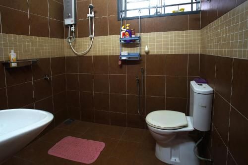 uma casa de banho com um WC, um lavatório e uma banheira em Teratak As-Sakinah em Merlimau