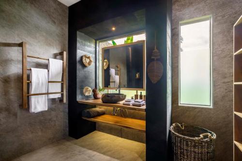 een badkamer met een wastafel en een spiegel bij Villa Mei in Ubud