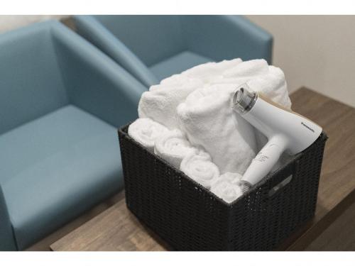 a basket with a electric toothbrush and towels at Kyo no yado en in Kyoto