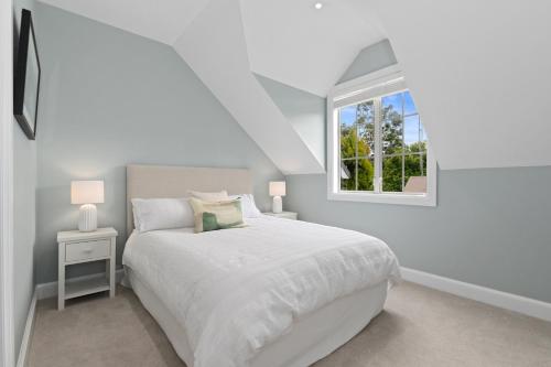 ein weißes Schlafzimmer mit einem Bett und einem Fenster in der Unterkunft A Sandy Jandal - Russell Holiday Home in Russell