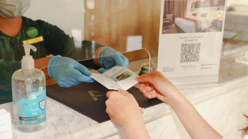 a person receiving a piece of paper with their hands at Patra Dumai Hotel in Dumai