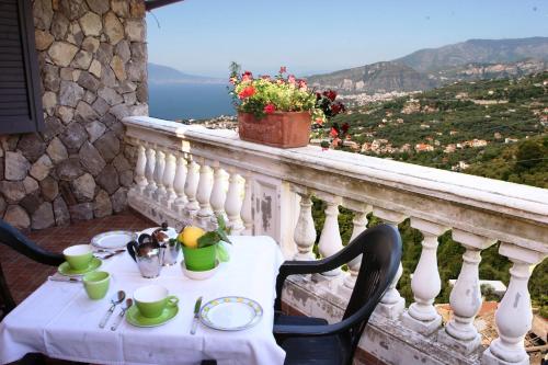 a table on a balcony with a view of the ocean at Casarufolo Paradise in Sorrento