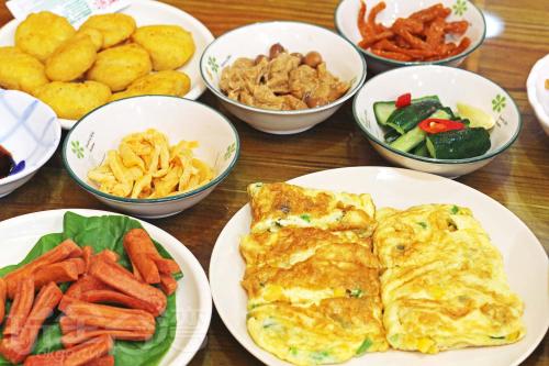a wooden table with plates of food and bowls of food at Sun Moon Lake Dream House B&B in Yuchi