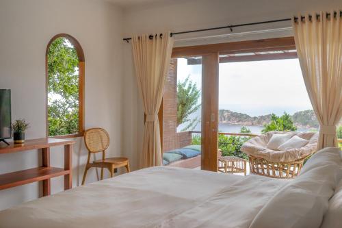 a bedroom with a bed and a window with a view at Baan Talay Koh Tao Resort & Yoga in Ko Tao