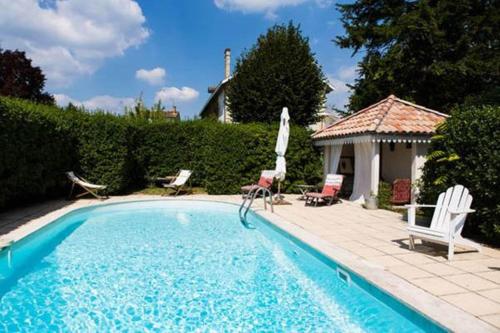 - une piscine avec 2 chaises et un kiosque dans l'établissement Château Beauséjour, à Listrac-Médoc