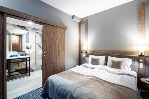 a bedroom with a large bed and a bathroom at Sezony. Restauracja i Hotel in Kostrzyn