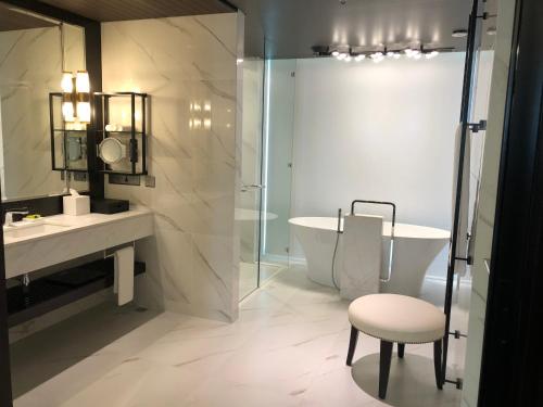 a bathroom with a tub and a sink and a chair at InterContinental Dhaka by IHG in Dhaka