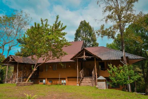 a large wooden house with a metal roof at Beyond Eco Living in Munnar