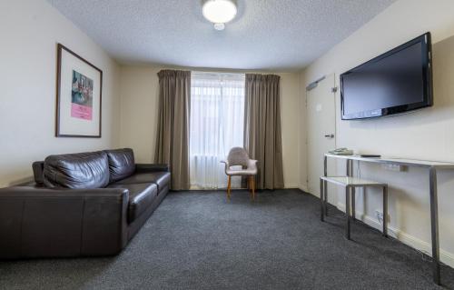 a living room filled with furniture and a tv at Forrest Hotel & Apartments in Canberra