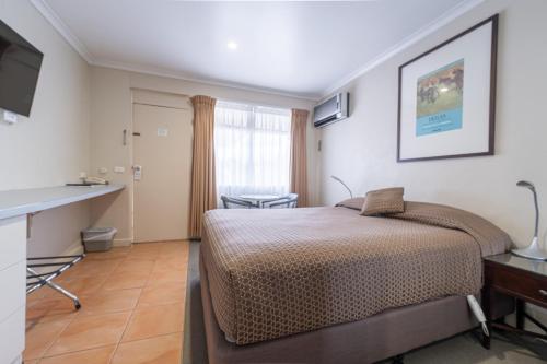 a hotel room with a bed and a desk at Forrest Hotel & Apartments in Canberra