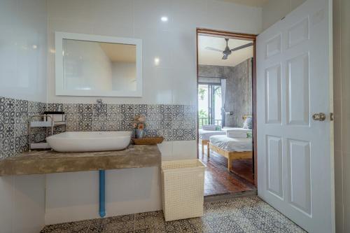 a bathroom with a sink and a mirror at New Heaven Dive School and Resort in Koh Tao