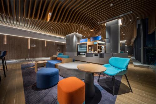 a lobby with blue and orange chairs and a table at Holiday Inn Express Zhuhai Gongbei by IHG in Zhuhai