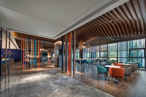 a restaurant with tables and chairs and windows at Holiday Inn Express Zhuhai Gongbei by IHG in Zhuhai