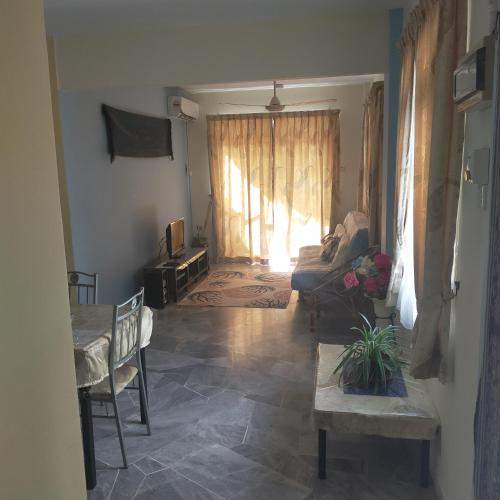 a living room with a couch and a window at Relaxing Retreats at Cocobay Apartments in Port Dickson