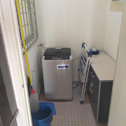 a small kitchen with a washer and dryer at Relaxing Retreats at Cocobay Apartments in Port Dickson