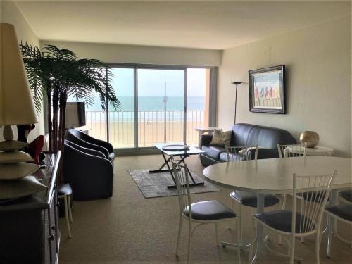 un salon avec une table, des chaises et un canapé dans l'établissement Le Calypso, à Les Sables-dʼOlonne