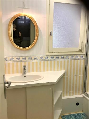 une salle de bain avec un lavabo et un miroir dans l'établissement Le Calypso, à Les Sables-dʼOlonne
