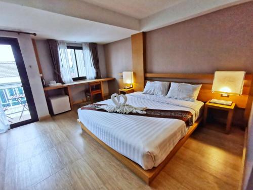 a bedroom with a large bed with a white bedspread at Buritel Hotel in Buriram