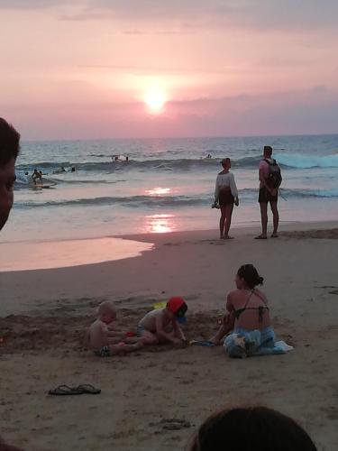 a group of people playing in the sand on the beach at Hotel Universal Beach in Hikkaduwa