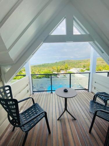 a room with two chairs and a table on a deck at Latitude 21 in Saint-Gilles les Bains