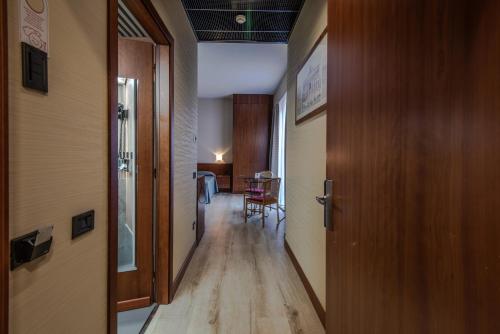 a hallway with a door and a room with a table at Hotel Petra in La Romanina