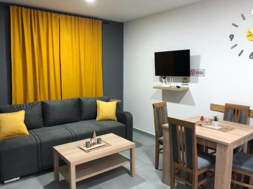 a living room with a couch and a table at Aphrodite Hills Apartments-Stara Planina in Crni Vrh