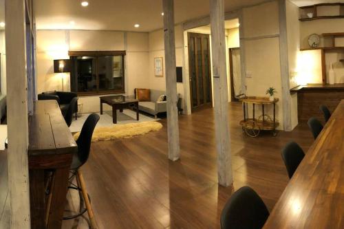 a large living room with a table and chairs at Riders Ridge Luxury Chalet sleeps 12 Ski In Ski Out Myoko in Akakura